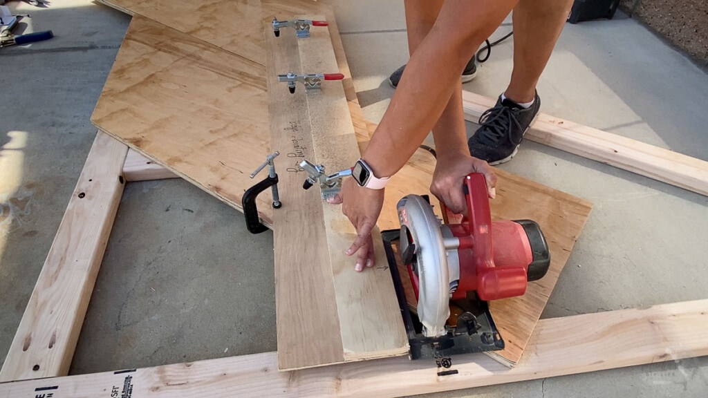 Woman using a plywood jig to make a straight cut with a circular saw