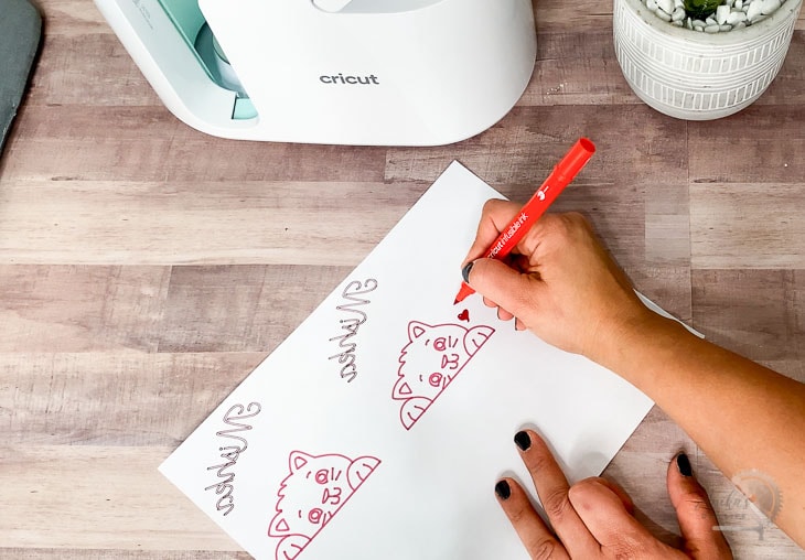 woman hand drawing designs on laser copy paper for Cricut MugPress