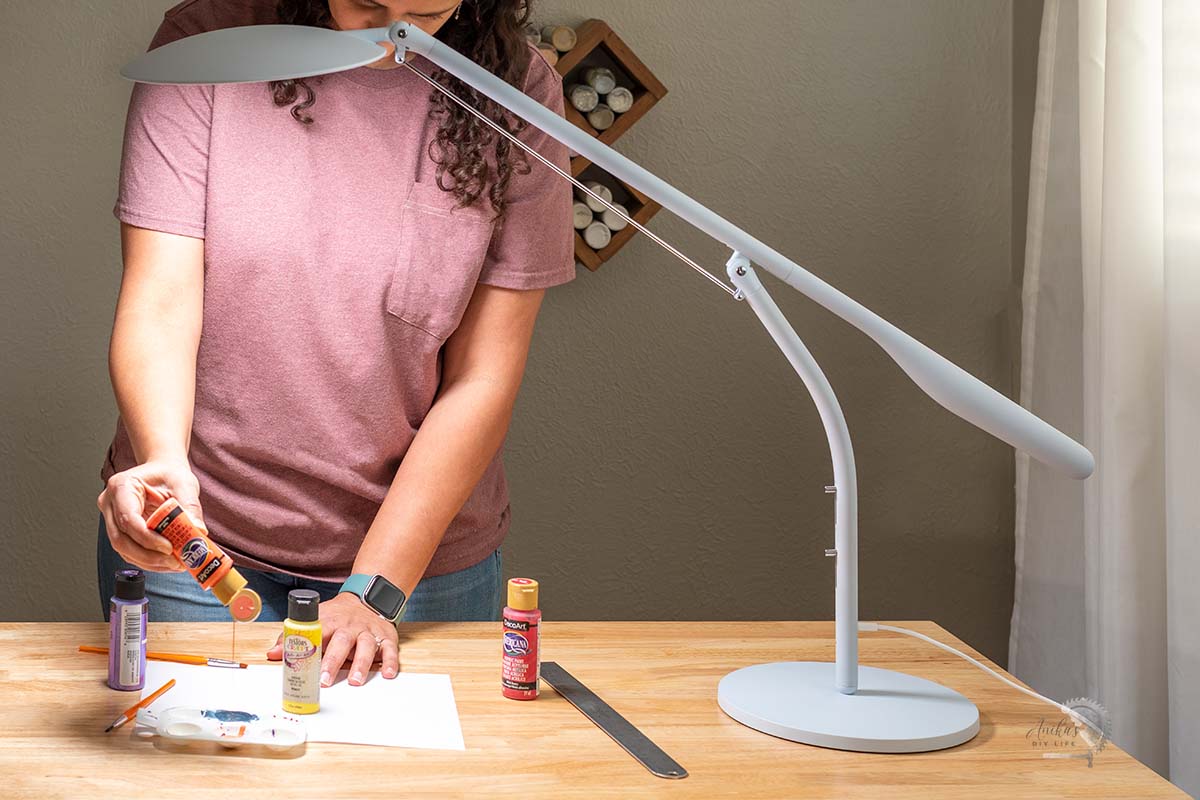 Woman painting on woirkbench with Cricut Bright 360
