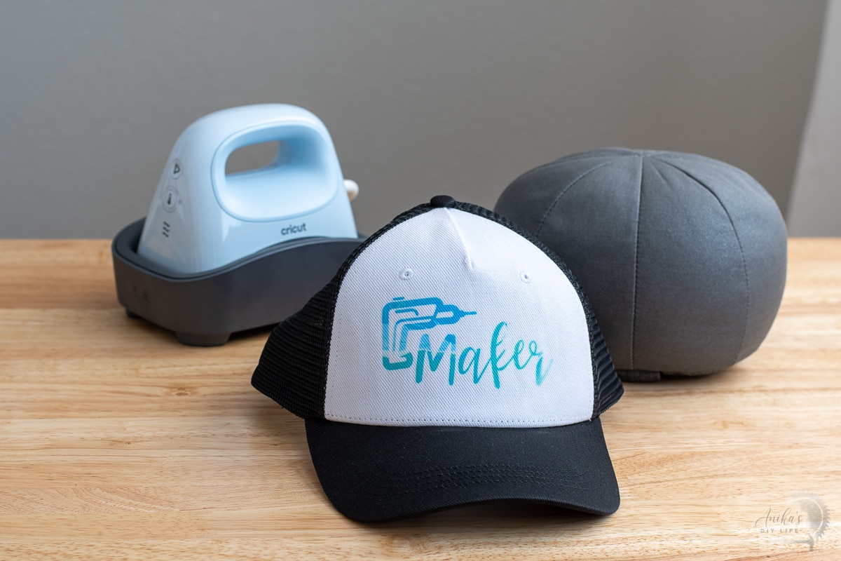 Trucker hat with "maker" design and hat press on table