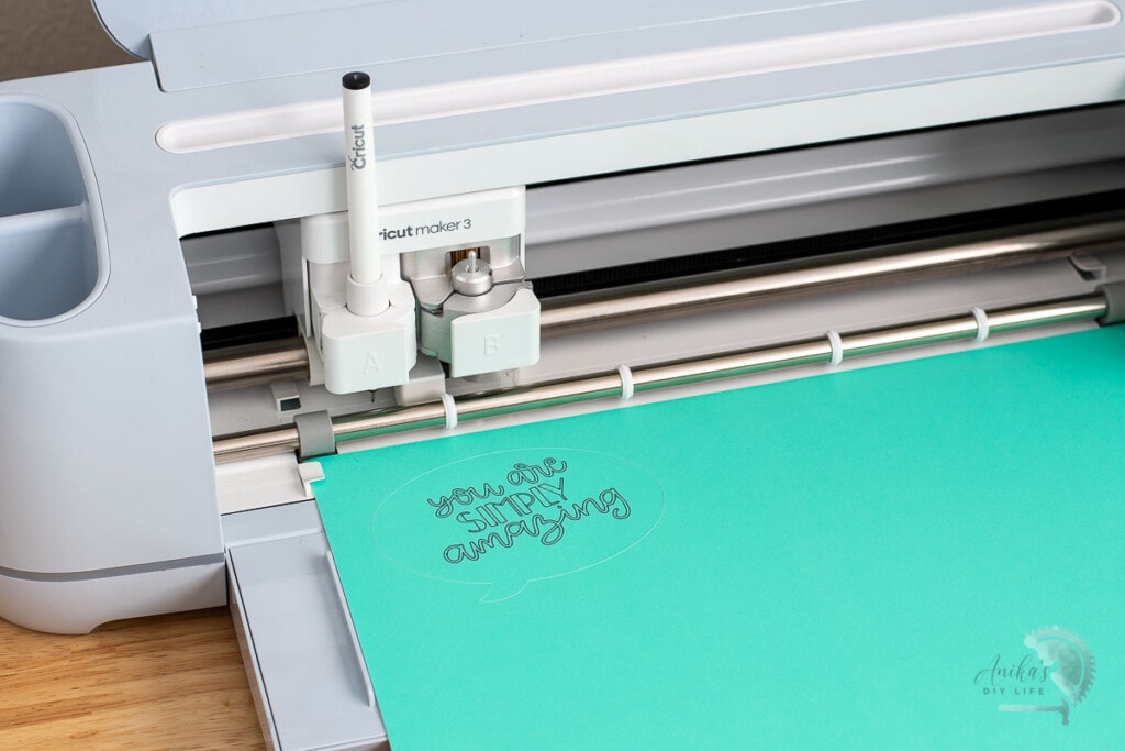 Cricut maker 3 writing and cutting a conversation bubble on teal paper