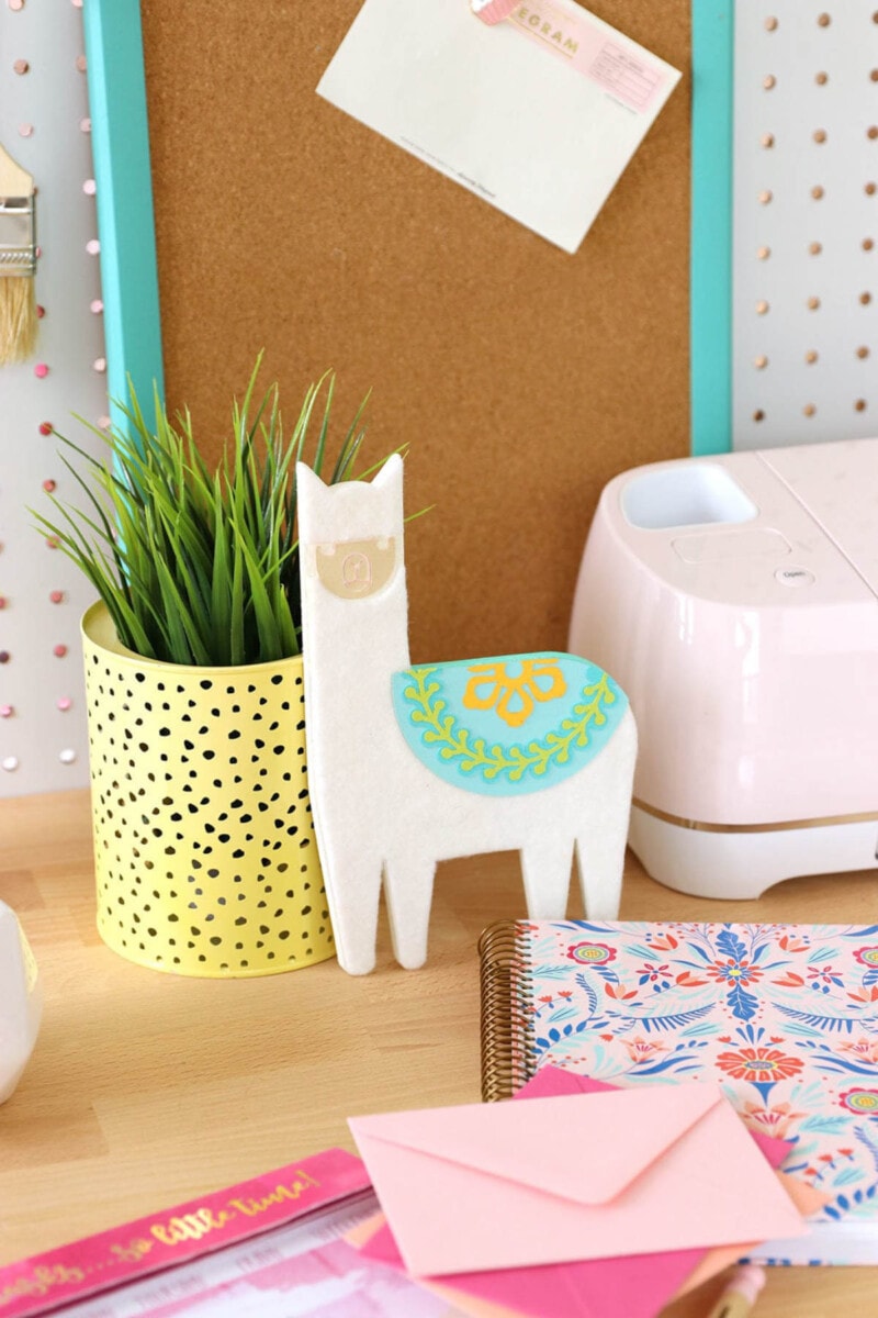 image of desk top with chipboard llama, succulent in a yellow pot and stationary