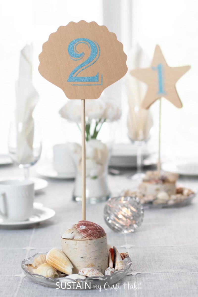 table number made from chipboard with seashells at the base