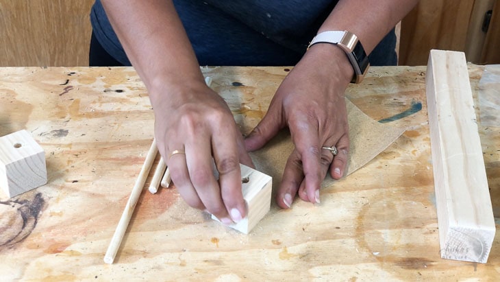 sanding dowels and wood blocks for a DIY baby mobile