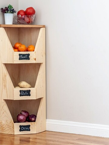 DIY corner vegetable storage bin with veggies and fruits in it.