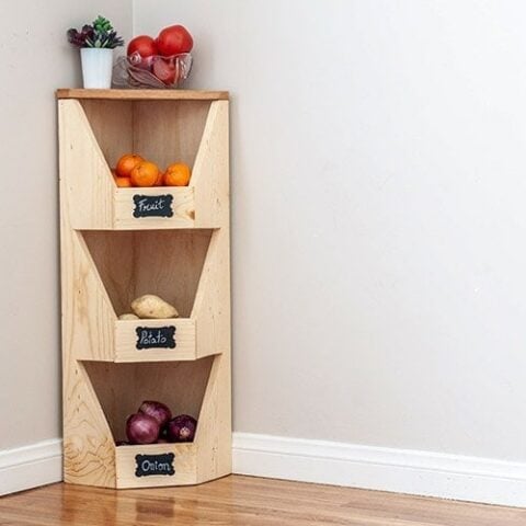DIY corner vegetable storage bin with veggies and fruits in it.