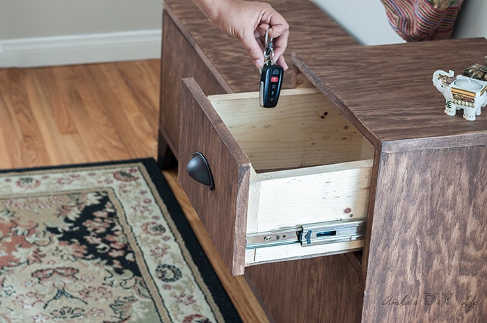 Dropping keys into the drawer of the DIY entryway bench