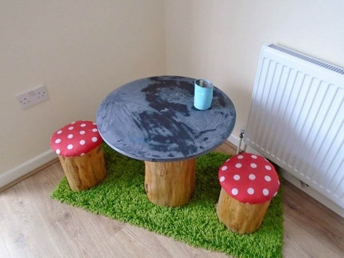 Kids table and chairs shaped like toadstools painted red with polka dots