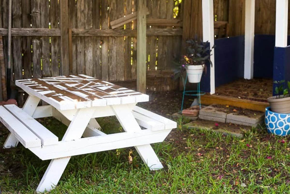 kids outdoor picnic table with white design painted top and attached benches
