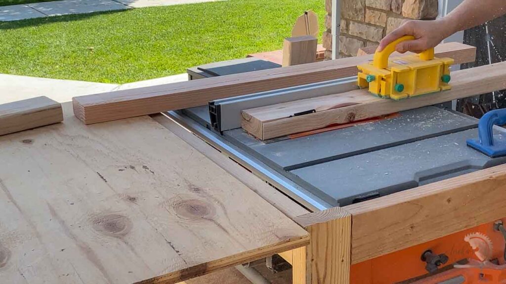 woman ripping 2x4 boards on table saw