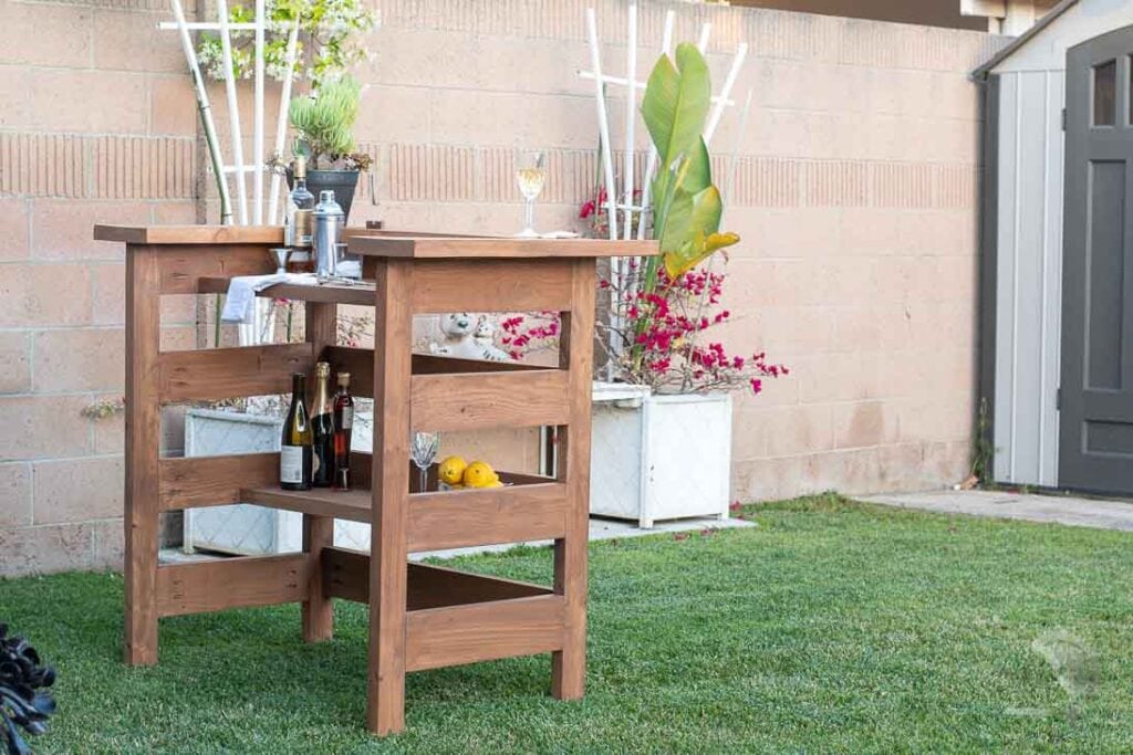 Homemade wooden outdoor bar in backyard with drinks on it