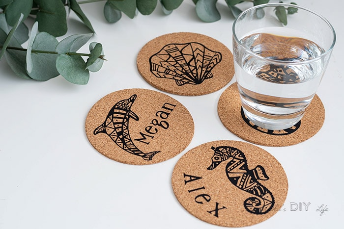 DIY cork coasters with cup of water on white table