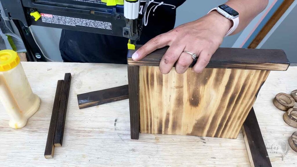 Attaching the boards to make a tic tac toe board using a brad nailer