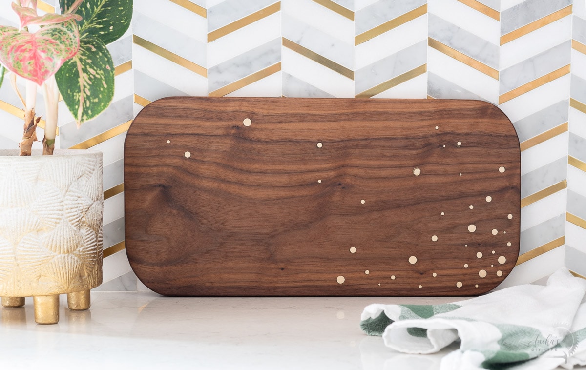 DIY walnut cutting board with brass inlay on countertop
