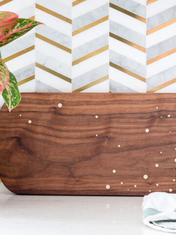 DIY walnut cutting board with brass inlay on countertop