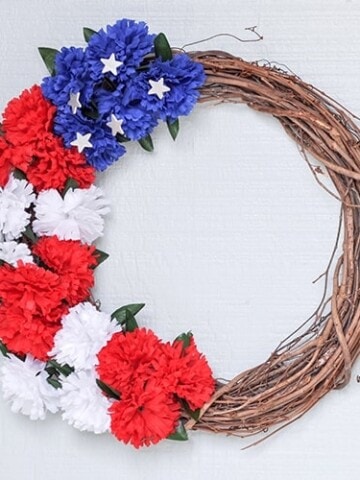 Learn how to make a red white and blue wreath for under $5 and 10 minutes using dollar store supplies. This easy American flag wreath makes the perfect DIY patriotic wreath for your front door! 