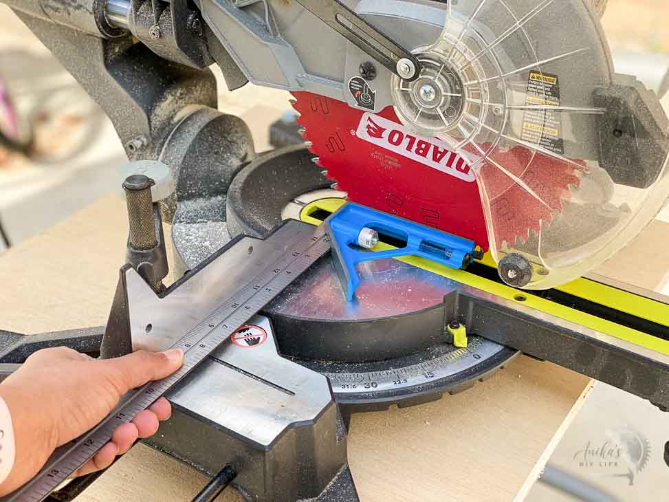 aligning the fence of the miter saw using a combination square to make accurate cuts