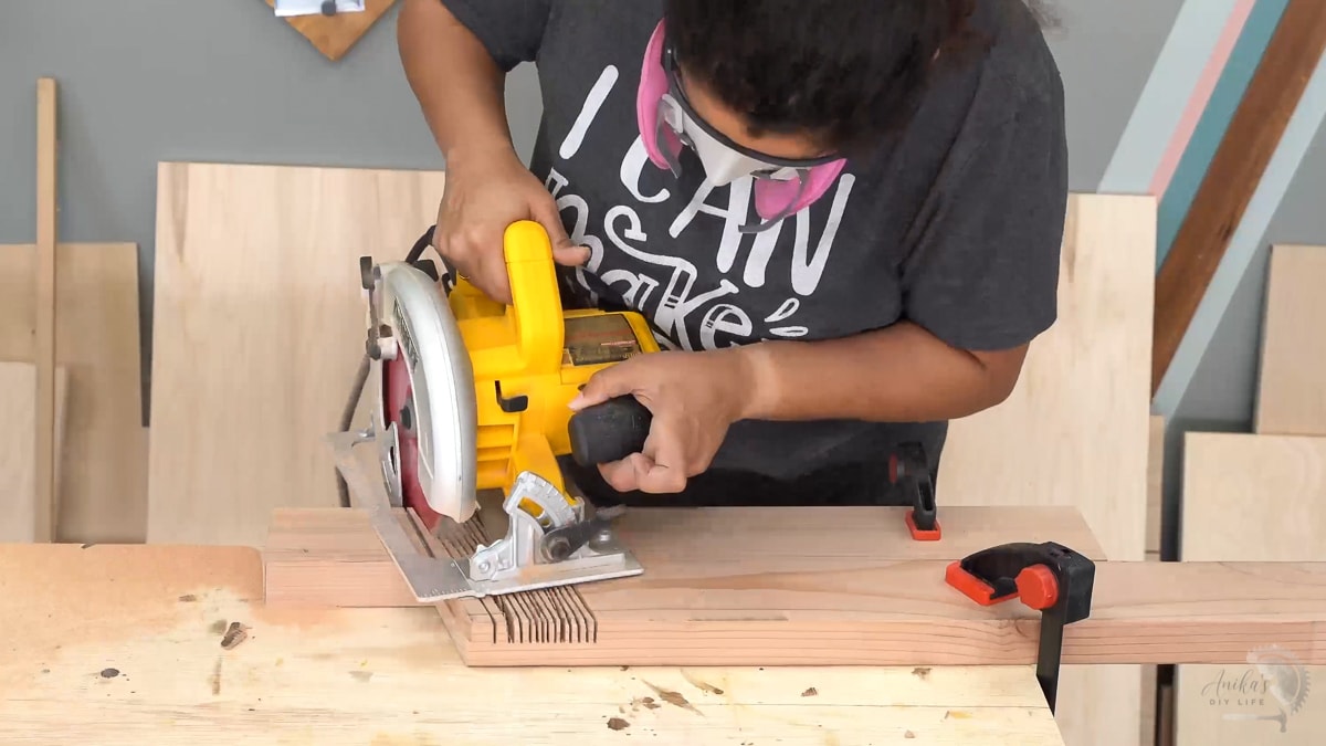 Woman making half lap cuts on 2x4 using a circular saw