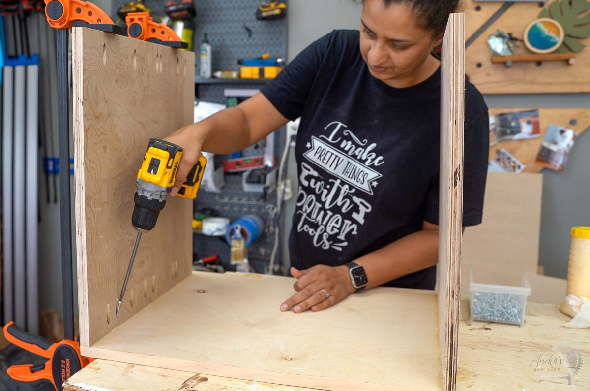 woman attaching plywood to build the nightstand
