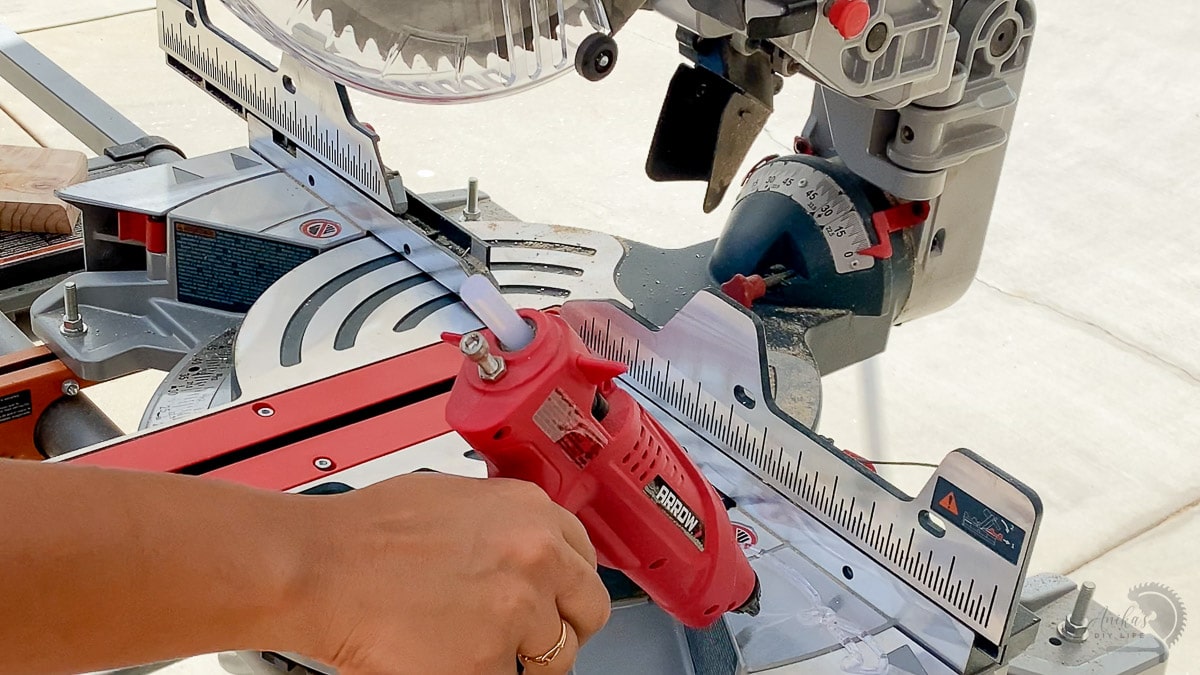 applying hot glue to the miter saw table