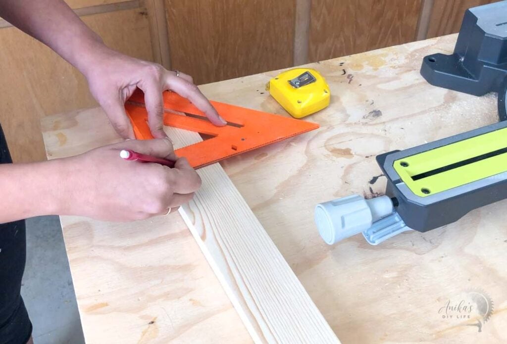 using a speed square to mark the cut line for a miter saw