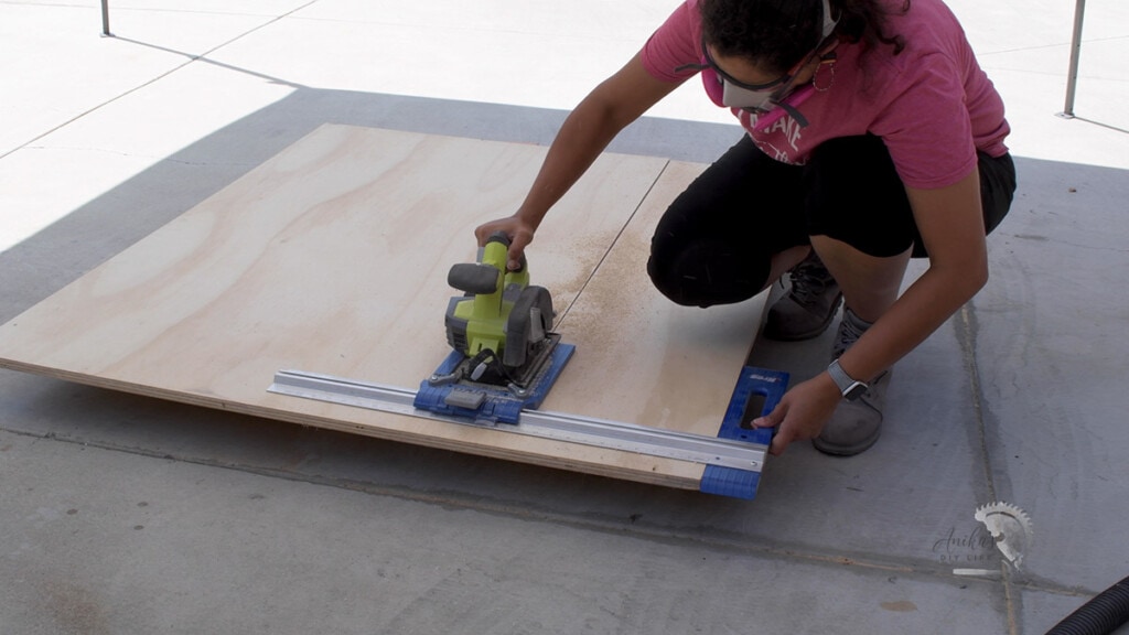 woman ripping plywood using a circular saw and a rip cut guide