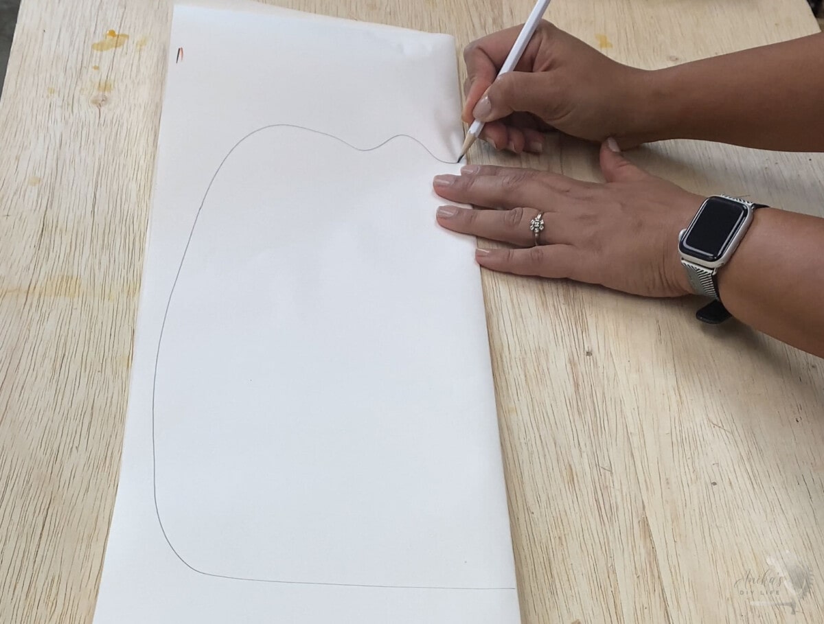 Drawing pumpkin shape on folded sheet of paper