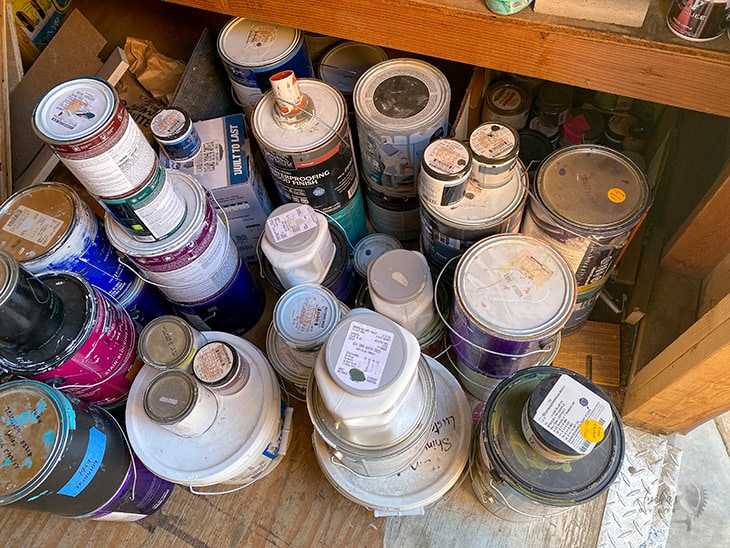 Cans of paint cluttered on floor