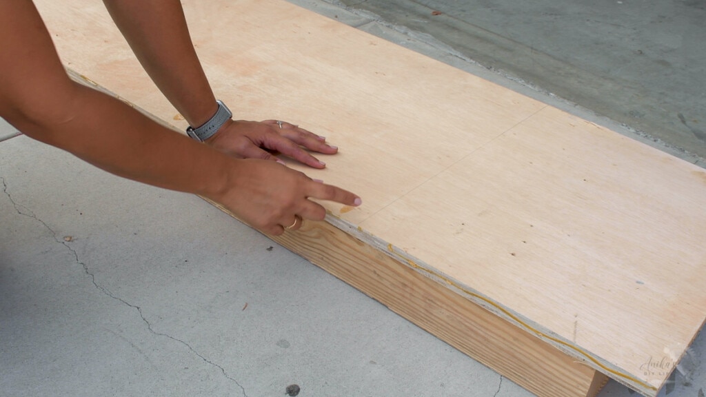 supporting the plywood using boards on floor to cut with a circular saw