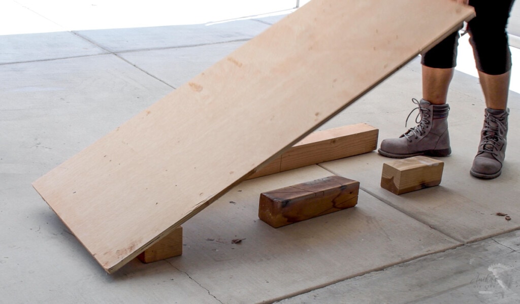 woman setting up the plywood to cut on the floor using structural lumber 
