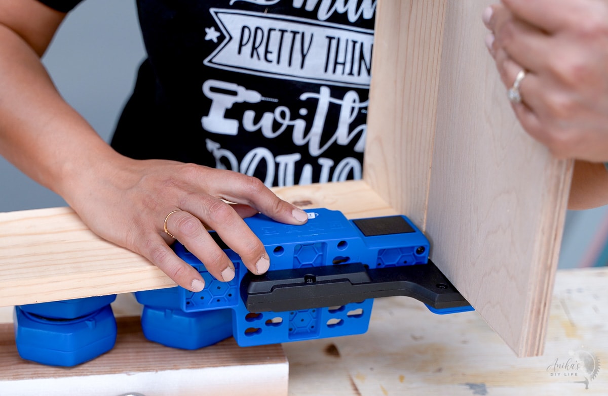 woman demonstrating how to use a cabinet door mounting jig 