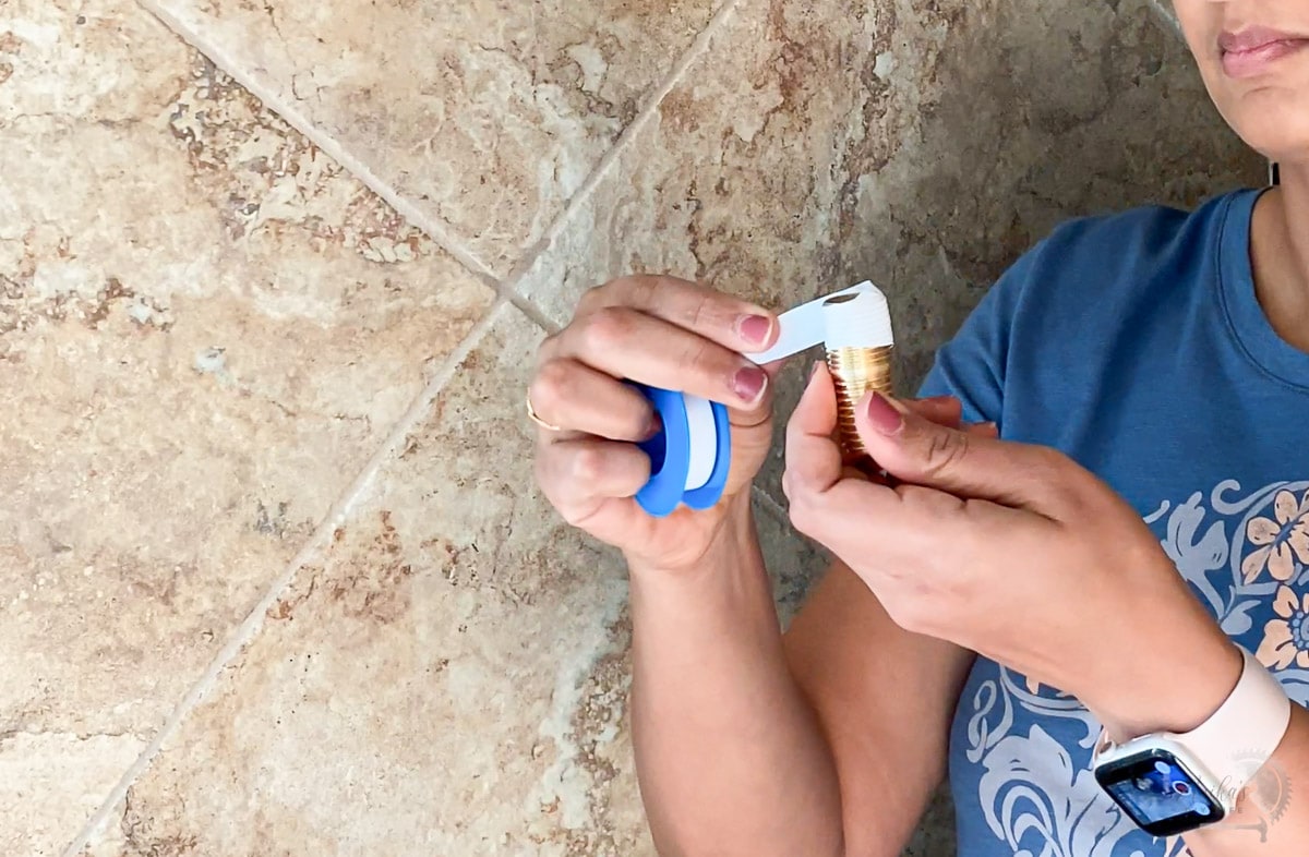 Woman applying thread seal tape to fittings to installl new showerhead