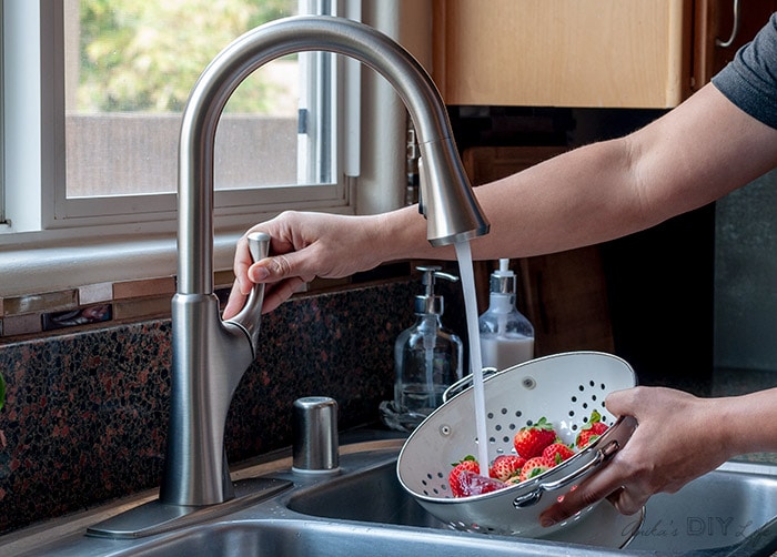 Using the newly installed kitchen faucet to wash straberries