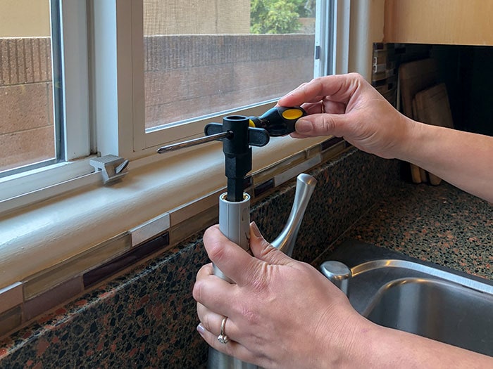 Attaching the faucet to the sink from the top.